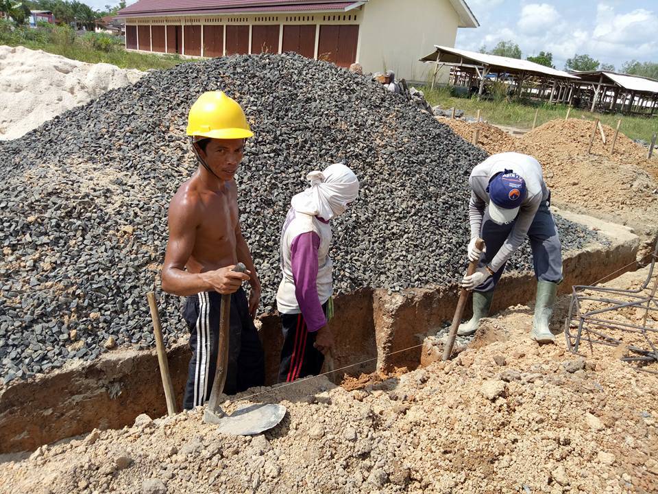 pekerja yang juga warga desa, sedang membangun balai desa wiralaga mulya. 